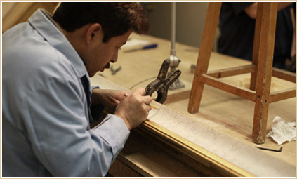 A skilled craftsman carefully marks a cut on a frame